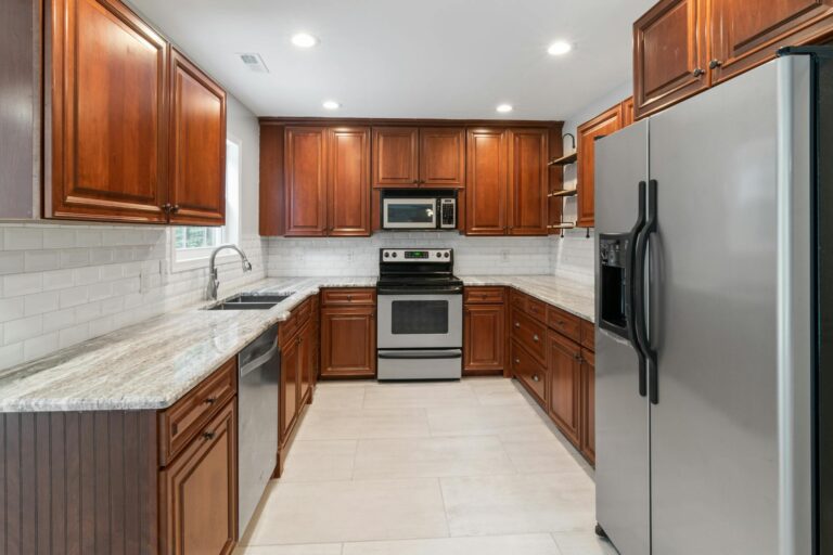 A Kitchen With Wooden Cabinets and New Appliances 