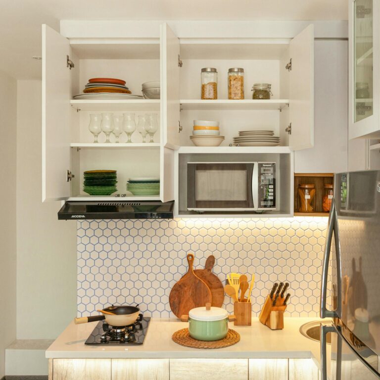 Plates and Clear Wine Glasses on White Wooden Kitchen Cabinet